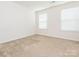 Bright bedroom featuring neutral carpet, two windows, and fresh, white walls at 709 Volta Nw Dr, Concord, NC 28027