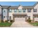 Inviting townhouse with a two-car garage, stone accents, manicured lawn, and colorful exterior at 709 Volta Nw Dr, Concord, NC 28027