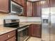 Well-lit kitchen with stainless steel appliances and dark wood cabinets at 709 Volta Nw Dr, Concord, NC 28027