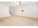 Bright and open living room featuring plush carpeting, staircase, and a wall mounted TV at 709 Volta Nw Dr, Concord, NC 28027