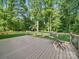 Back deck featuring a table and chairs, bordered by a wooden fence, looking out onto a spacious lawn at 7344 Maitland Ln, Charlotte, NC 28215