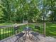 A backyard deck featuring a table and chairs with a view of the spacious, tree-lined yard at 7344 Maitland Ln, Charlotte, NC 28215