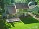 Aerial view of a home featuring a rear deck, a spacious lawn, and complemented by mature trees at 7344 Maitland Ln, Charlotte, NC 28215