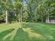 Backyard with a shed, a fence, and mature trees, creating a private and serene outdoor space at 7344 Maitland Ln, Charlotte, NC 28215
