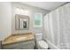 Bathroom features a granite vanity, window for natural light, and a tub with shower at 7344 Maitland Ln, Charlotte, NC 28215