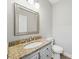Bright half bathroom with granite countertop, framed mirror and stylish fixtures at 7344 Maitland Ln, Charlotte, NC 28215