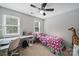 Cozy bedroom featuring a ceiling fan, a comfortable single bed, and a dedicated study desk for added functionality at 7344 Maitland Ln, Charlotte, NC 28215