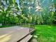 A wooden deck overlooks a well-manicured lawn surrounded by lush greenery and mature trees at 7344 Maitland Ln, Charlotte, NC 28215