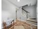Foyer area with tile floors, stairs leading up, and a wood table against a light grey wall at 7344 Maitland Ln, Charlotte, NC 28215
