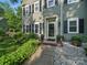 Charming home featuring a landscaped front yard, green siding, black shutters, and a welcoming front door at 7344 Maitland Ln, Charlotte, NC 28215