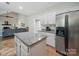 Kitchen with white cabinets, stainless steel appliances, and granite countertops that flows into the living room at 7344 Maitland Ln, Charlotte, NC 28215