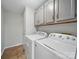 Well-organized laundry room featuring overhead cabinets and modern appliances for efficient laundry management at 7344 Maitland Ln, Charlotte, NC 28215