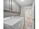 Functional laundry room equipped with cabinets, washer, and dryer for convenient household chores at 7344 Maitland Ln, Charlotte, NC 28215