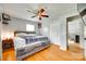 Well-lit bedroom with a wooden bed frame, hardwood floors, and access to closet and office at 739 Springdale Rd, Rock Hill, SC 29730