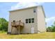 Back of house with a wooden deck, white vinyl siding, and a door to the basement at 7601 Hammond Dr, Charlotte, NC 28215