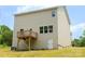 View of the back of a house with a deck, windows and a door to the basement at 7601 Hammond Dr, Charlotte, NC 28215