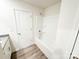 Clean bathroom showcases a tub and shower, white door, and updated fixtures at 7601 Hammond Dr, Charlotte, NC 28215