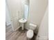 Cozy powder room features a pedestal sink, modern toilet, and neutral wall paint at 7601 Hammond Dr, Charlotte, NC 28215