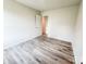 An empty bedroom featuring light gray walls and light wood-look flooring, offering a neutral and adaptable space at 7601 Hammond Dr, Charlotte, NC 28215