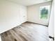 Bedroom with closet, window and gray wood-look vinyl flooring throughout at 7601 Hammond Dr, Charlotte, NC 28215