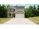 Charming two-story home features a two-car garage and neutral siding, set against a backdrop of lush trees at 7601 Hammond Dr, Charlotte, NC 28215