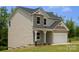 Front exterior of a two-story home featuring a gray roof, tan siding, and an attached garage at 7601 Hammond Dr, Charlotte, NC 28215