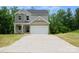 Home exterior with gray roof, tan siding, two stories, large driveway and an attached garage at 7601 Hammond Dr, Charlotte, NC 28215