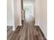 Hallway with gray wood floors leading to a well lit area with large windows and white trim at 7601 Hammond Dr, Charlotte, NC 28215