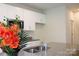 Modern kitchen featuring white cabinets, stainless steel microwave, granite countertops, and an island with a sink at 7601 Hammond Dr, Charlotte, NC 28215