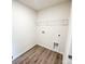 Neat laundry room with modern wood-look flooring and a wire shelf, offering a functional and organized space at 7601 Hammond Dr, Charlotte, NC 28215
