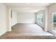 Open-concept living area featuring hardwood floors, large windows, and easy access to the outdoor deck at 7601 Hammond Dr, Charlotte, NC 28215