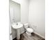 Modern powder room featuring a pedestal sink, toilet, wood-look floors, and ample natural light at 7601 Hammond Dr, Charlotte, NC 28215