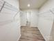Functional walk-in closet with white wire shelving and wood-look flooring at 7601 Hammond Dr, Charlotte, NC 28215