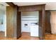 Convenient laundry area features ample shelving and wood paneled walls, blending functionality with rustic charm at 761 Milton Ave, Rock Hill, SC 29730