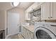 Well-equipped laundry room with stone accent wall, granite countertops, and ample storage space at 7916 Deerbridge St, Mint Hill, NC 28227