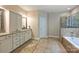 Bright bathroom boasts double vanities, ample cabinetry, soaking tub, and glass shower at 7916 Deerbridge St, Mint Hill, NC 28227