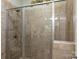 Modern tiled shower featuring glass door and chrome fixtures in neutral tones at 7916 Deerbridge St, Mint Hill, NC 28227