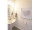 The powder room features a pedestal sink, decorative mirror, and a butterfly-themed wall art piece at 8177 Sheffield Dr, Terrell, NC 28682