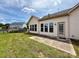 The backyard with sliding glass doors, patio, and level lawn with wood fence at 8429 Olde Stonegate Ln, Mint Hill, NC 28227