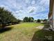 Beautiful backyard with green lawn, mature trees, and wooden fence, offering privacy at 8429 Olde Stonegate Ln, Mint Hill, NC 28227