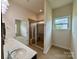 Bright bathroom with double sink, ceramic tile flooring, and a glass-enclosed shower at 8429 Olde Stonegate Ln, Mint Hill, NC 28227