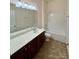 Bathroom with vanity sink, a large mirror, and a bathtub with a shower at 8429 Olde Stonegate Ln, Mint Hill, NC 28227