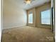 A bedroom featuring two windows and neutral colored walls at 8429 Olde Stonegate Ln, Mint Hill, NC 28227