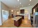 Open-concept kitchen with a large island, stainless steel appliances, and hardwood flooring at 8429 Olde Stonegate Ln, Mint Hill, NC 28227