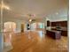 Open-concept living area with hardwood floors seamlessly connecting to kitchen and dining spaces at 8429 Olde Stonegate Ln, Mint Hill, NC 28227