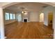 Bright living room with hardwood floors, a fireplace, and arched doorways to other rooms at 8429 Olde Stonegate Ln, Mint Hill, NC 28227