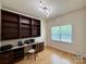 A home office featuring built-in bookshelves, a desk, and hardwood floors at 8429 Olde Stonegate Ln, Mint Hill, NC 28227