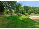 Lush backyard with manicured lawn, mature trees, and a stone path leading to the pool area at 8433 Cheverny Dr, Waxhaw, NC 28173