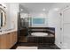 Elegant bathroom featuring a separate shower, tub, and wooden cabinets at 8433 Cheverny Dr, Waxhaw, NC 28173