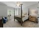 Bedroom with a four-poster bed, neutral decor, and natural light from the windows at 8433 Cheverny Dr, Waxhaw, NC 28173